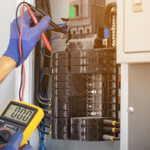 Electrician installing a ceiling fan and checking wiring at a Denver home