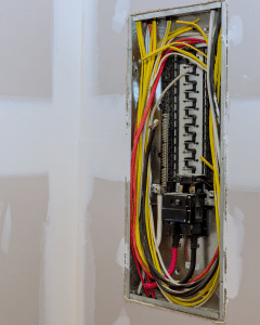 Professional electrician from Karisma Electric inspecting a residential electrical panel for safety issues in Parker, CO.